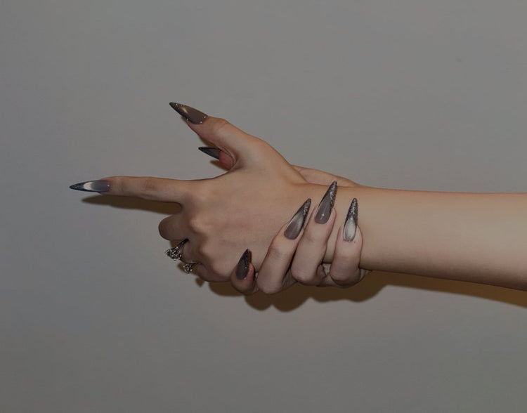 Hand model showcasing Snaps Chic press-on nails with a gun gesture